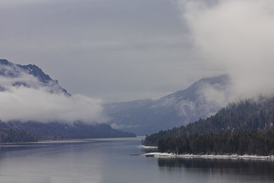 Scenic view of lake by snowcapped mountains against sky