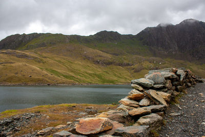 Scenic view of river and mountains against sky