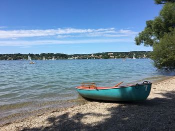 Sailboats moored on sea against sky