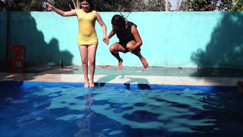 People jumping in swimming pool