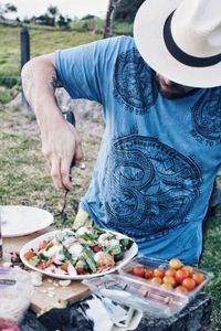 Midsection of man preparing food on field