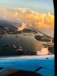 Aerial view of swimming pool by sea against sky during sunset