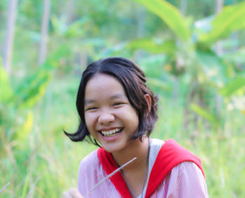 Portrait of smiling girl against plants