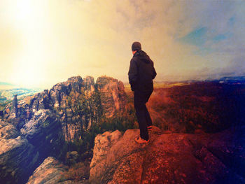 Rear view of man looking at mountain against sky