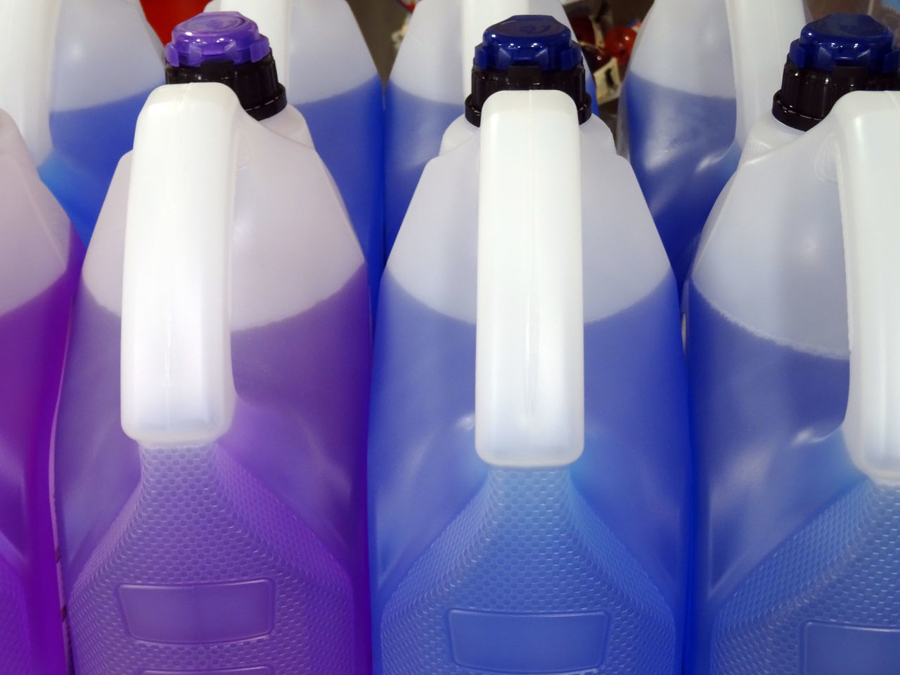 CLOSE-UP OF WHITE WINE BOTTLES ON SHELF IN ROW