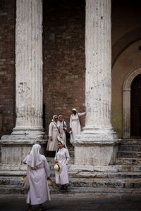 Rear view of people outside temple against building