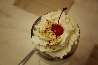 Close-up of vanilla ice cream with cherry served on table