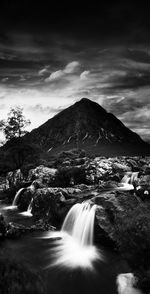 Scenic view of waterfall against sky