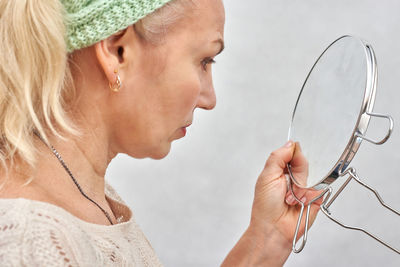 Close-up portrait of young woman holding eyeglasses