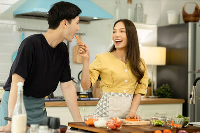 Woman standing by food in kitchen