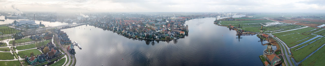 High angle view of cityscape by river against sky