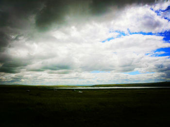 Scenic view of landscape against cloudy sky