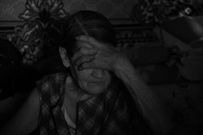 Senior woman sitting with head in hands at home