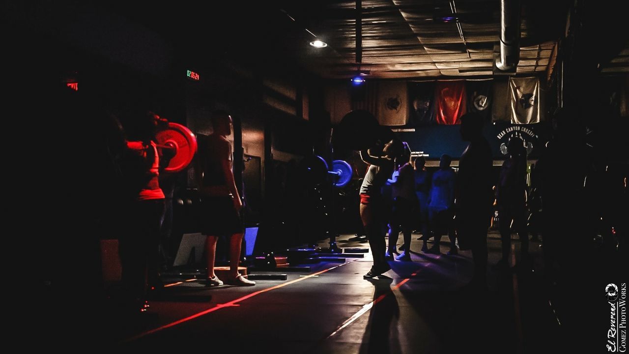 PEOPLE STANDING IN ILLUMINATED STORE