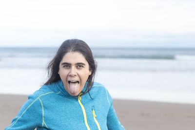 Woman on the beach making fun sticking her tongue out at the camera