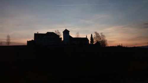 Low angle view of silhouette built structure against sky at sunset