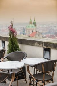 Empty chairs and tables against sky