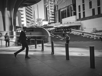 Full length of man walking on street against buildings in city