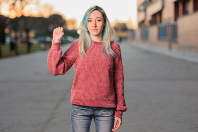 Portrait of young woman standing on road