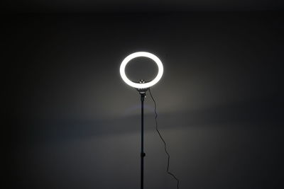 Illuminated electric lamp against dark background