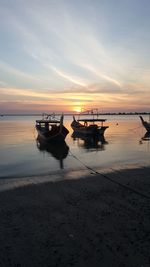 Silhouette boat on beach against sky during sunset