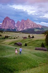 Rear view of couple on field against mountains