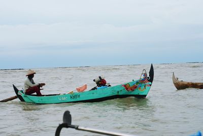 Fishing boats in sea against sky