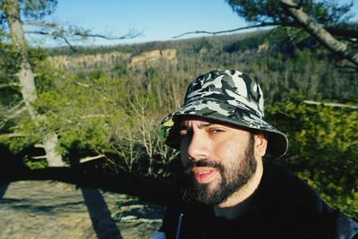 Portrait of man wearing sunglasses against trees