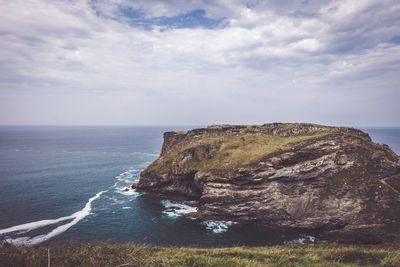 Rock formation on sea against sky