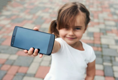 Portrait of smiling girl holding camera