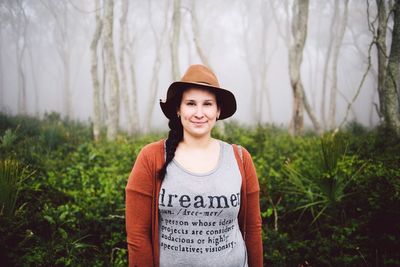 Portrait of happy young woman standing on grass