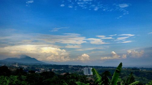 View of cityscape against cloudy sky