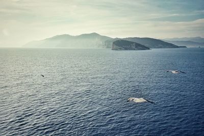 Scenic view of sea and mountains against sky