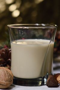 Close-up of milk in glass amidst nuts