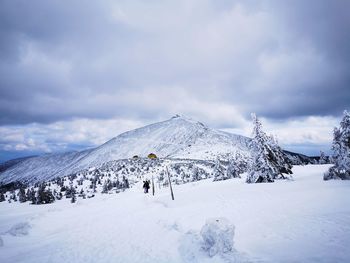 People on snowcapped mountain against sky