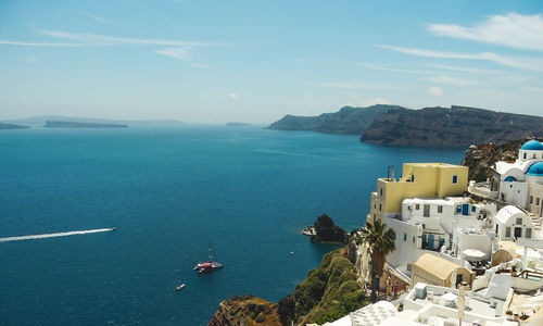 High angle view of sea by town against sky