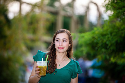 Beautiful tourist girl drinking a traditional lulada at the jairo varela square in the city of cali