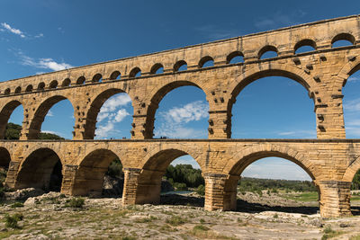 Low angle view of old aqueduct ruins pont du gard against clear sky