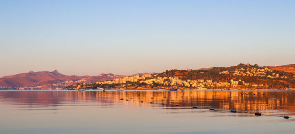 Scenic view of lake against clear sky during sunset