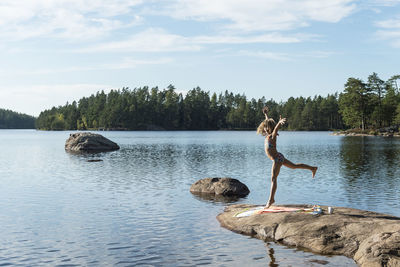 Girl standing on rock at lake