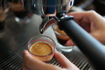 Cropped image of hand holding coffee cup