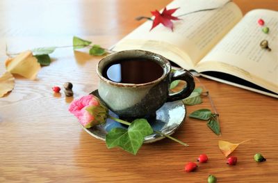 Close-up of cup of coffee and book on table