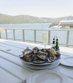 Food on table by sea against sky