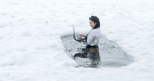 Rear view of woman standing on snow covered field