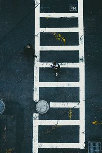 High angle view of woman walking on crosswalk