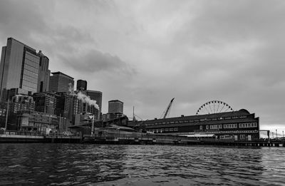 Bridge over river against buildings in city