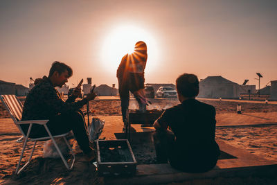 People sitting at beach during sunset