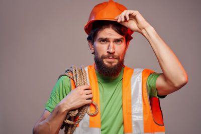 Portrait of mid adult man standing against orange background