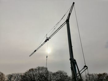Low angle view of crane against sky at dusk