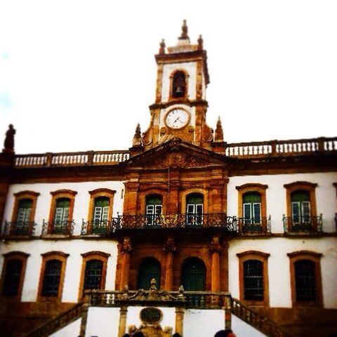 architecture, built structure, building exterior, window, clear sky, arch, low angle view, facade, city, travel destinations, clock, clock tower, history, sky, travel, car, transportation, incidental people, outdoors, building